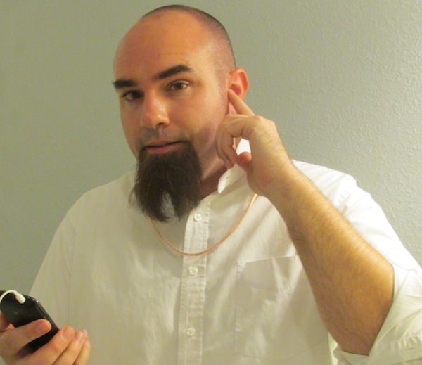 Photo of Rich Lee showing off the headphones implanted in his ear