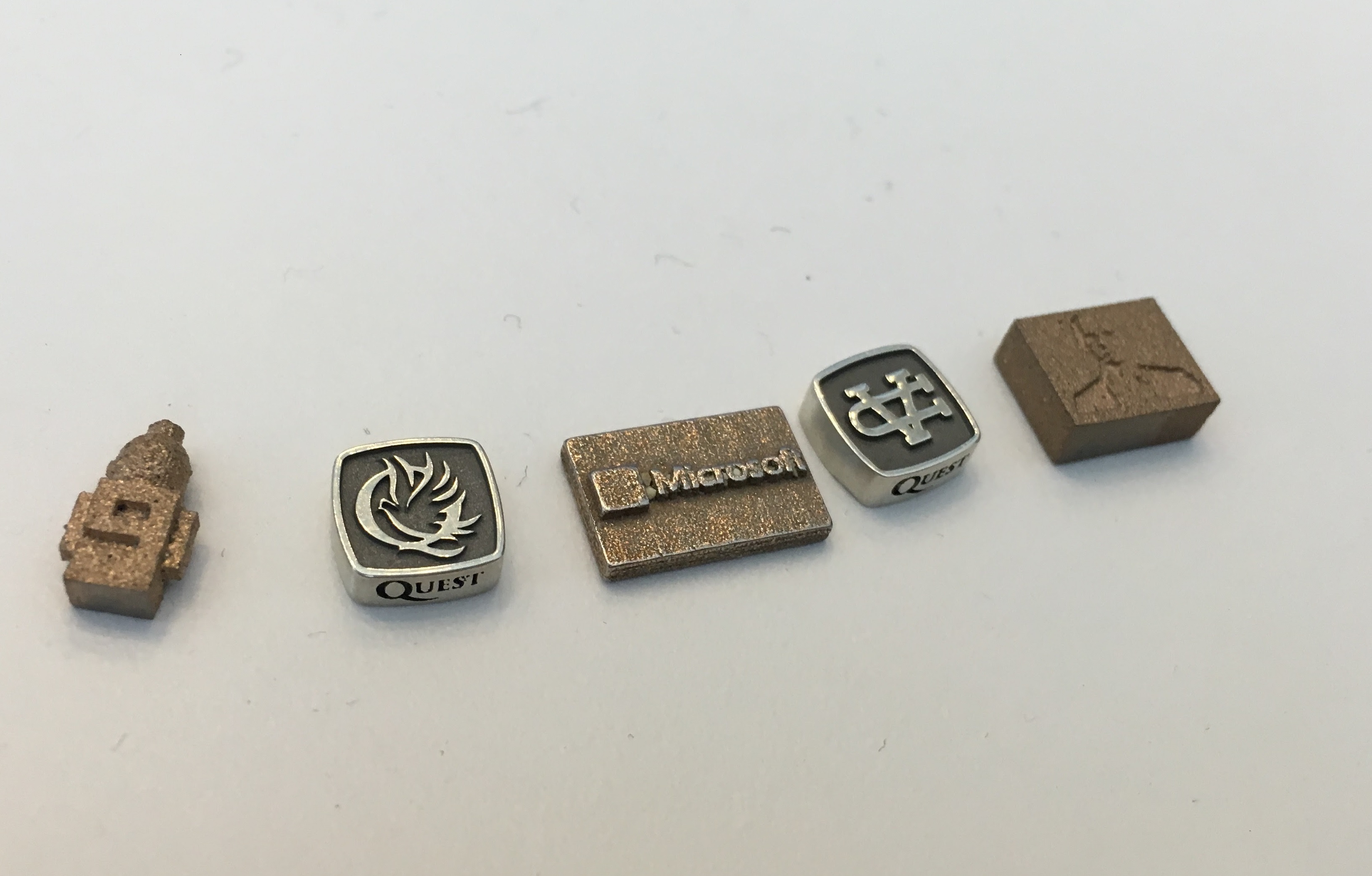 Some of the pieces that will be tested in space. The one on the far left represents Microsoft's Channel 9. The middle one is Microsoft's logo. The one of the far right is a bust of Microsoft chief executive Satya Nadella. The second and fourth are logos of the Valley Christian Schools.