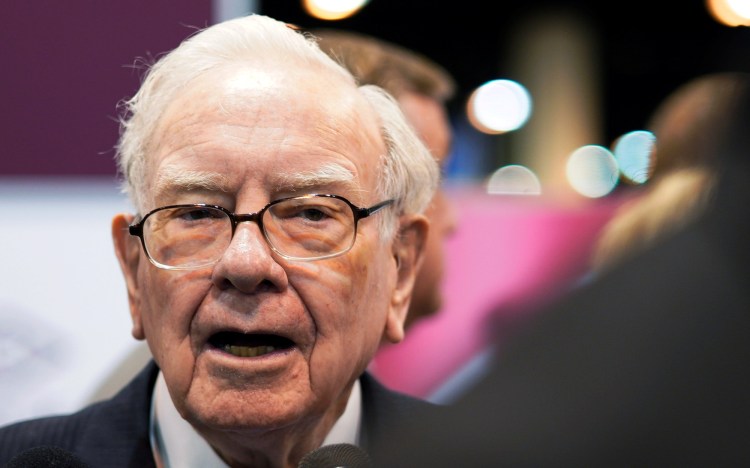 Warren Buffett, CEO of Berkshire Hathaway Inc, talks to a reporter in the exhibit hall at the company's annual meeting in Omaha, Nebraska, U.S., May 5, 2018.