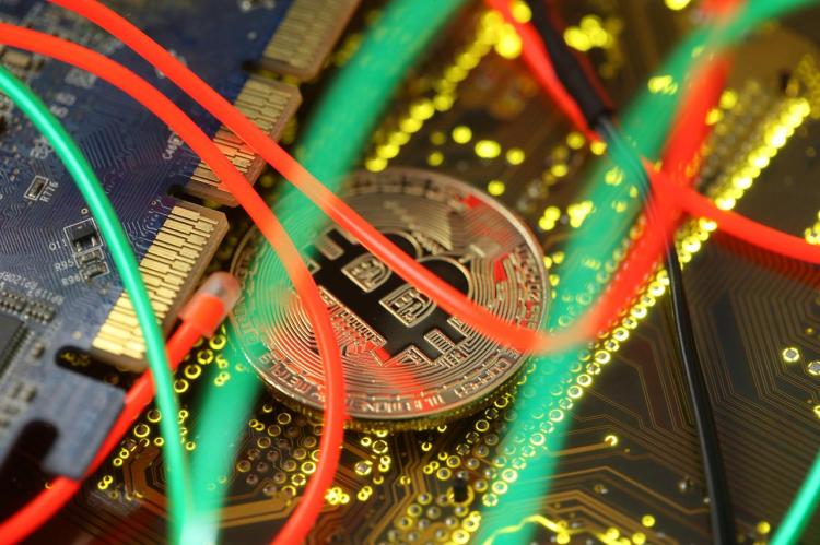 Representation of the Bitcoin virtual currency standing on the PC motherboard is seen in this illustration picture, February 3, 2018. 