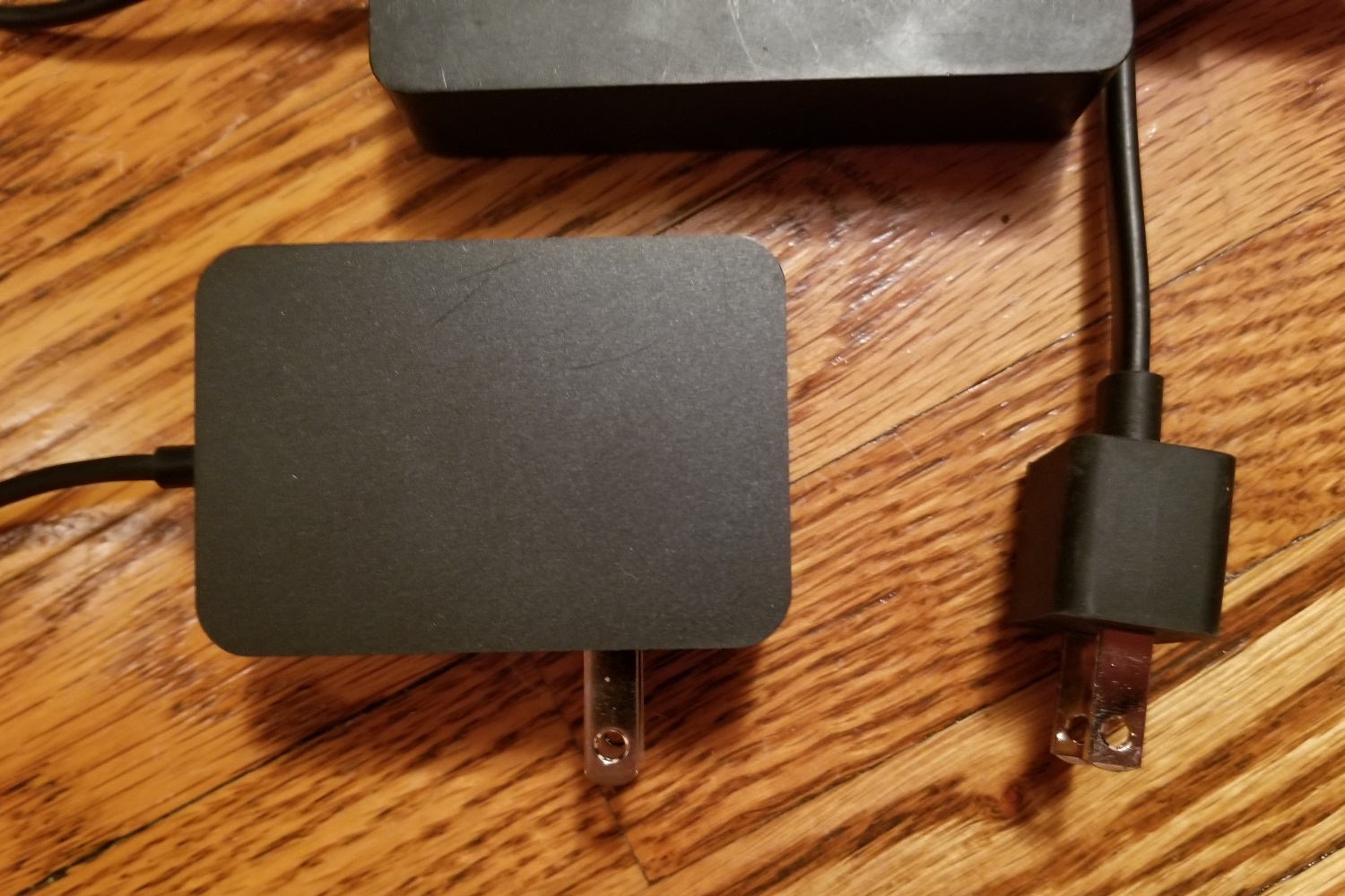Surface Go power adapter beside a Surface Laptop power adapter