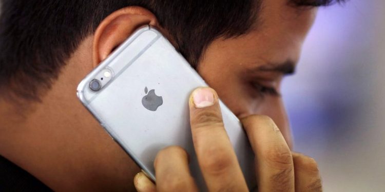 A man talks on his iPhone at a mobile phone store in New Delhi, India, July 27, 2016. 